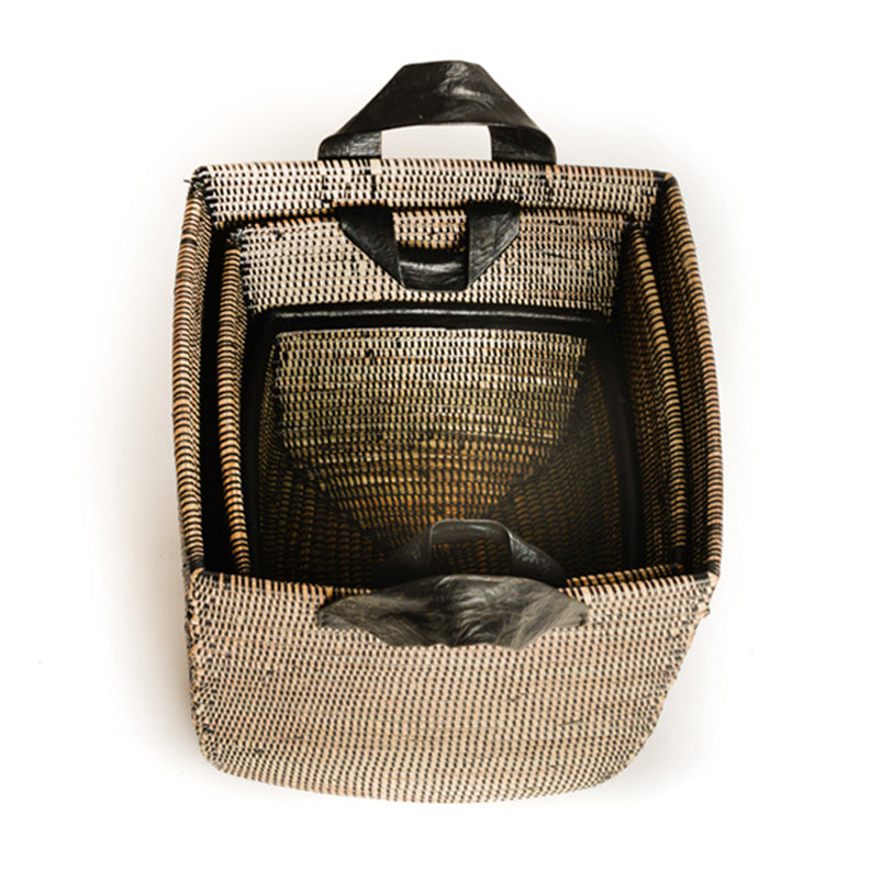 Nested woven baskets with black leather handles. Baskets have black detail.