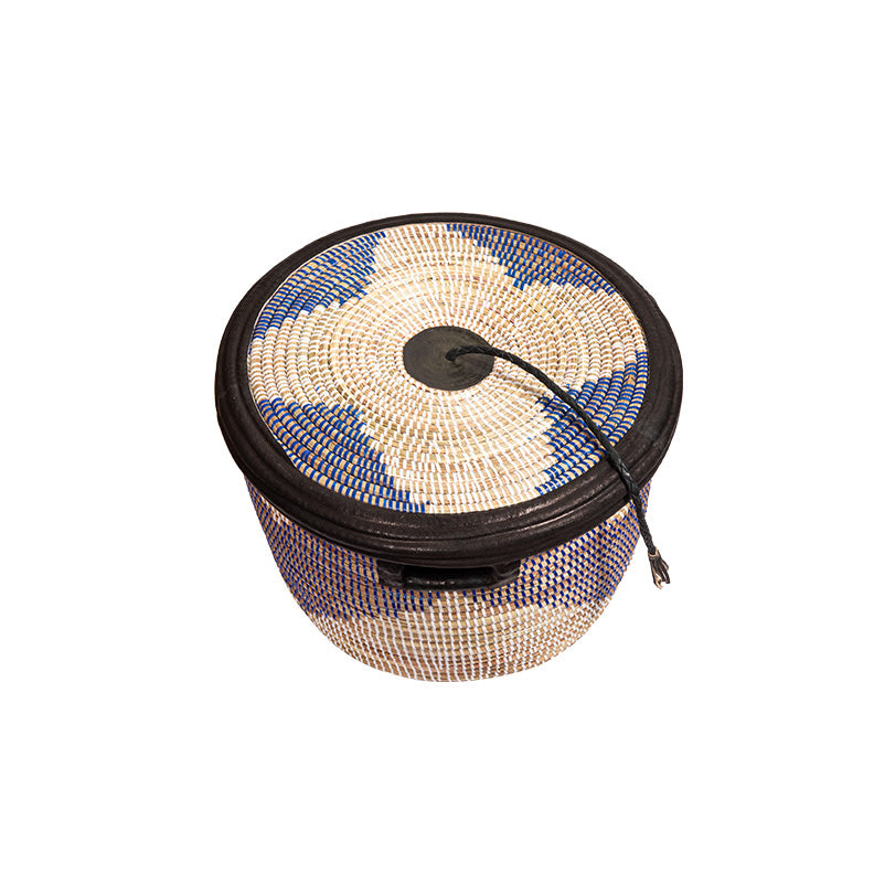 Coumba basket. A rounded woven basket with dark blue pattern on white. Black leather trim and tassel on lid. View is from the top.