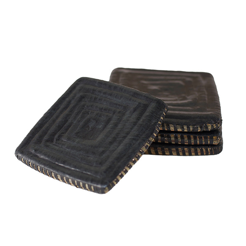 Square coaster stack on white. Woven and covered in black leather.