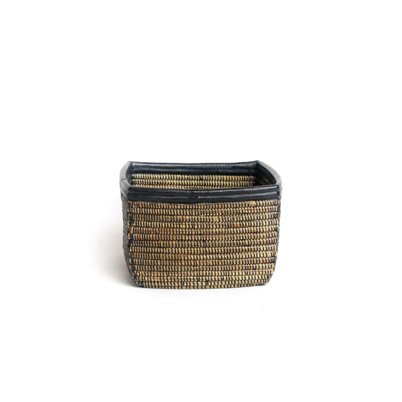 Busso basket on white. A square woven basket with black detail including a black leather trim. View is from the side.