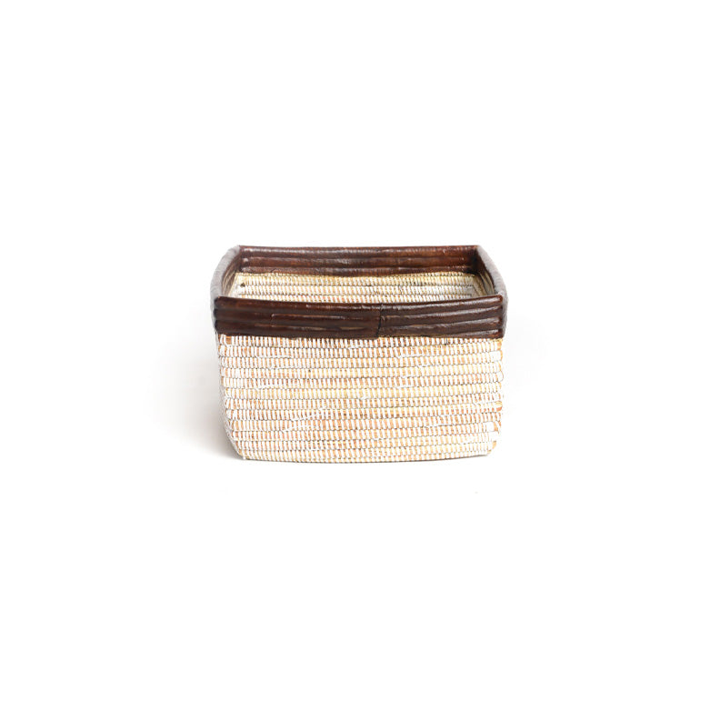 Busso basket on white. A square woven basket with brown detail including a milk chocolate brown leather trim. View is from the side.